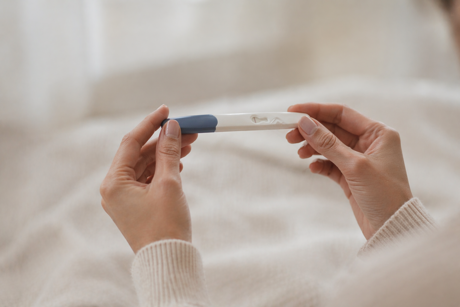 Two hands holding a pregnancy test